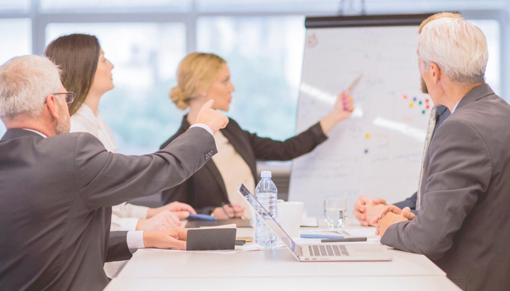 Bureau avec ordinateur affichant des graphiques financiers et documents